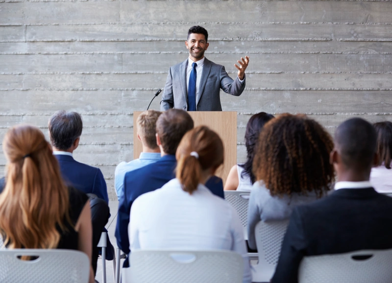 A man in suit and tie giving a presentation.